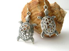 Pretty turtle charms hang from silver colored ear wire. The large charms have lots of detail. The earrings are 2.25 inches long. Book Earrings, Turtle Shell, Turtle Charm, Turtle Earrings, Earrings Etsy, Bead Designs, Cute Earrings, Ear Wire, Silver Color