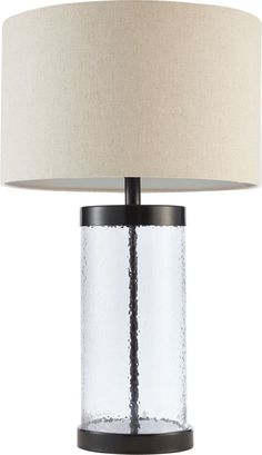 a glass table lamp with a beige shade on it's base and a black metal frame