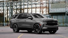 the new chevrolet suv is parked in front of an industrial building with scaffolding