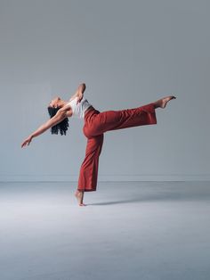 two dancers in red pants and white shirts are doing an acrobatic move