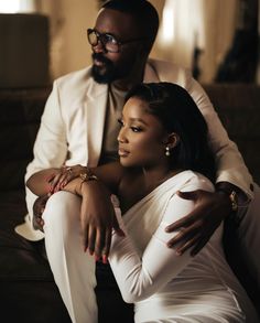 a man sitting next to a woman on top of a couch