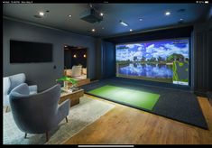 a living room with a large screen on the wall