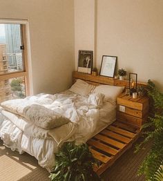 an unmade bed with white sheets and pillows in a bedroom next to a window