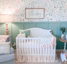 a baby's room with a crib, chair and wall papered walls