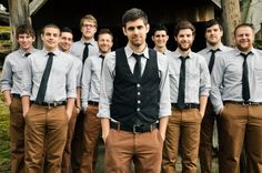 a group of young men standing next to each other in front of a wooden structure