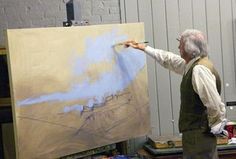 an older man is painting in his studio