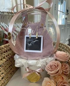 a pink purse sitting on top of a table next to flowers and a basket filled with photos