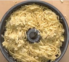 spaghetti being cooked in a pan on top of a stove burner with the lid down