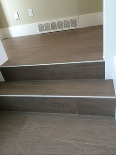 a set of stairs leading up to an empty room with hard wood flooring and white walls