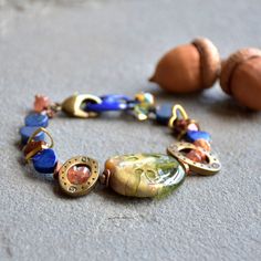 "Add panache to any denim day with this gorgeous beaded bracelet! Handmade with love using only the finest components, including: artisan lampwork glass focal, enameled link, lampwork glass teardrop, lapis hearts, fresh water coin pearls, sunstone rondelles, antique brass beads, raw brass hearts, etched copper wavy discs, and an antique brass lobster clasp. This beauty measures . . . about 7\" A must have for your lovely wrist! Packaged carefully and ships quickly." Artisan Beaded Glass Bracelets, Artisan Glass Beaded Bracelets, Artisan Czech Glass Jewelry Bracelet, Artisan Czech Glass Bracelet, Bohemian Murano Glass Jewelry Gift, Handmade Artisan Glass Beaded Bracelets, Adjustable Czech Glass Beaded Bracelets, Unique Adjustable Czech Glass Beaded Bracelets, Artisan Bracelets With Colorful Czech Glass Beads