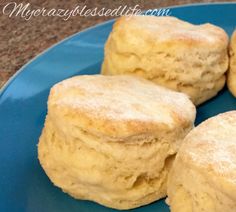 four biscuits on a blue plate sitting on a counter