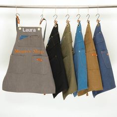 four aprons hanging on a clothes line with the name laura written on them