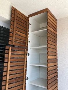 an open closet with wooden shutters and shelves