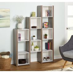 a living room filled with furniture and a white book shelf next to a chair on top of a hard wood floor