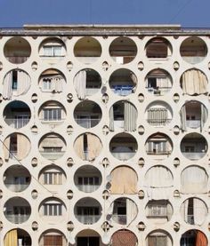 an apartment building with many round windows and balconies on the front, all in white