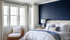 a bedroom with blue walls and white bedding