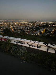 a white surfboard with graffiti on it sitting in front of a cityscape