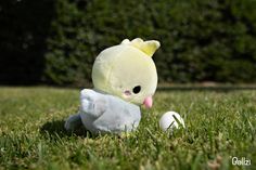 a small stuffed animal sitting in the grass next to an egg