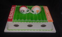 a cake with two footballs on top of it in the shape of a field