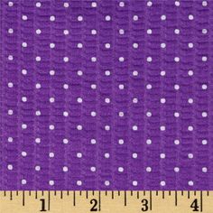 purple and white polka dot print fabric with ruler on the right side, showing it's width