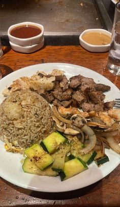 a white plate topped with meat, rice and veggies