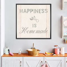 a kitchen with a sink and cabinets underneath a framed sign that says happiness is homemade