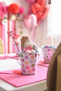 the table is decorated with hearts and pinks for valentine's day party decorations