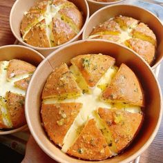 four breads with cheese and herbs are in small bowls on a wooden table, ready to be eaten