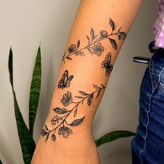 a woman with a tattoo on her arm has a butterfly and flower design on it