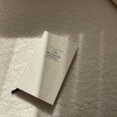 an open book laying on top of a white carpet