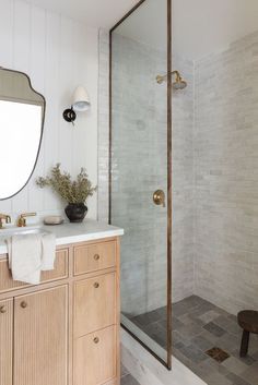 a bathroom with a sink, mirror and shower stall in it's own home