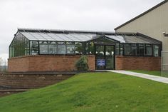 a brick building with a glass roof and stairs leading up to the side of it