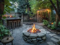 an outdoor fire pit surrounded by greenery and patio furniture with lights on the top