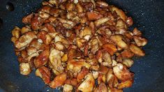 chicken and nuts cooking in a pan on the stove