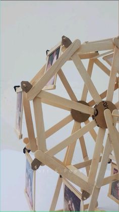 a sculpture made out of wooden sticks and pictures