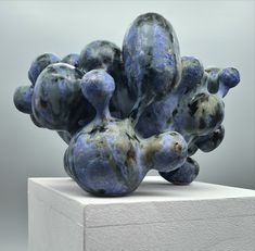 a blue sculpture sitting on top of a white block