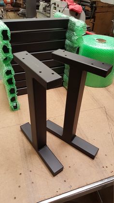 two black metal tables sitting on top of a table covered in green plastic wrappers