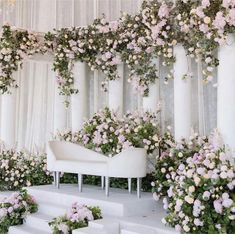 a white couch sitting on top of a set of stairs covered in pink and white flowers