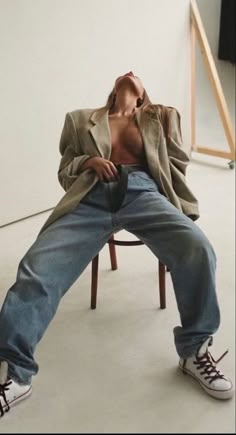 a man is sitting on a chair with his shirt off and shoes in the air