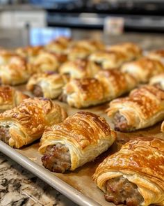 many pastries are lined up on a baking sheet