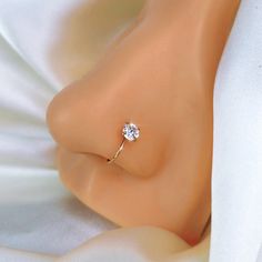 a close up of a person's nose with a diamond ring on top of it