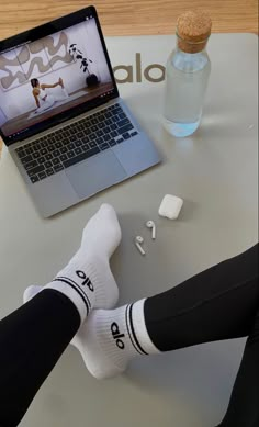 a person sitting at a table with their feet up on the desk next to a laptop