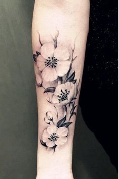 a black and white flower tattoo on the arm