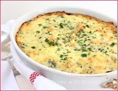 a casserole dish with cheese and parsley in it on a white plate