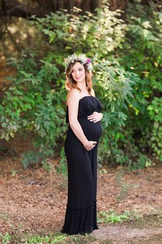 a pregnant woman wearing a flower crown poses for a photo