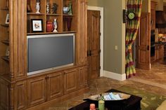 a living room filled with furniture and a flat screen tv on top of a wooden entertainment center