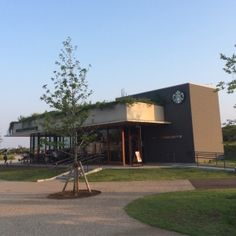 a building with a clock on the side of it's face and trees in front of it