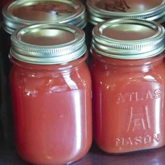 four jars filled with liquid sitting on top of a table