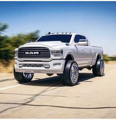 a white ram truck driving down the road