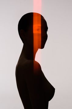 the silhouette of a woman is shown with an orange light behind her head and body